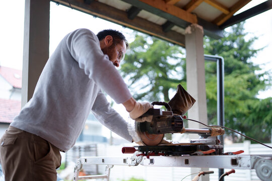 Man using a saw in a workshop during daylight
