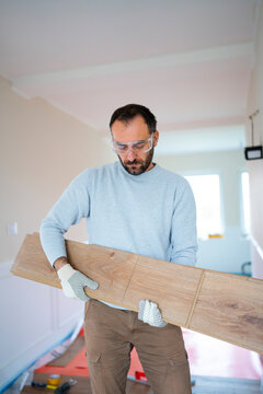 Man works with wood flooring in a house