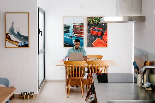An online business owner in a dining room, using a computer