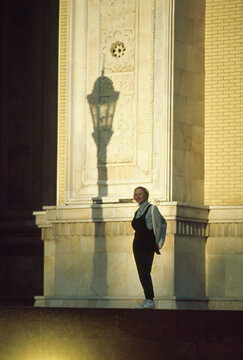 Woman by Sunlit Facade