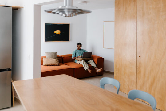 Self-employed man embraces hybrid lifestyle working from living room