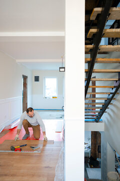 Worker lays flooring in a home renovation project