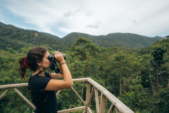Young woman using binoculars for bird watching
