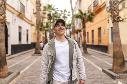 Happy man walking towards the camera on a street in Cadiz, Spain