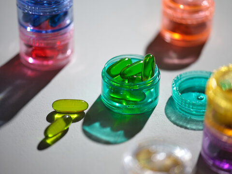 Colorful capsules in small jars, a health and wellness concept
