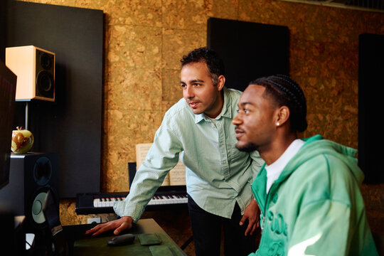 Music Producers Collaborating on Audio Project. Home Recording Studio