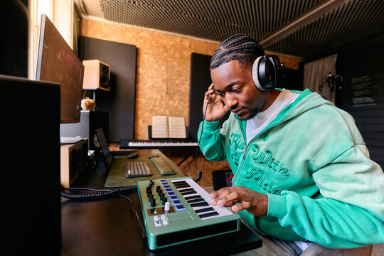 Music Producer Creating Music on MIDI Keyboard Controller Home Studio