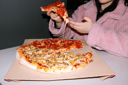 Woman Holding Pizza Slice