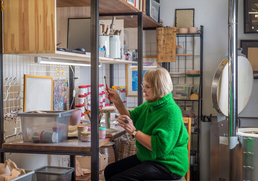 Female elderly artist at work in art studio