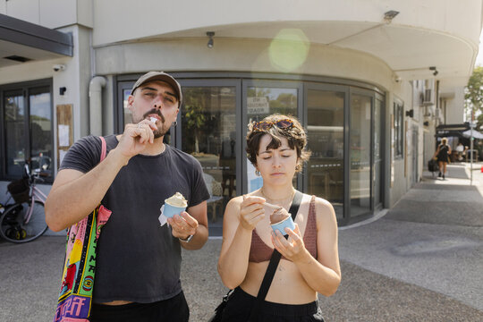 Portrait of couple eating ice cream outdoors with flare