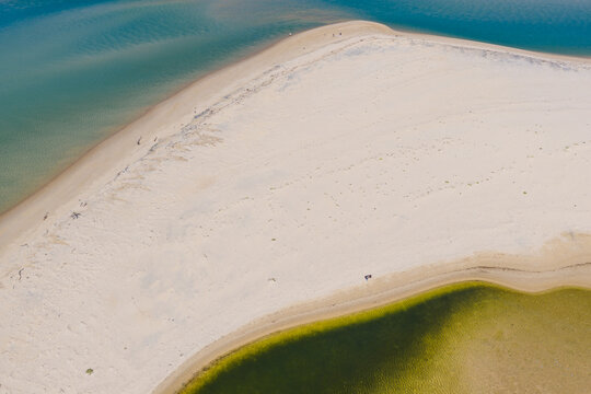 A wide flat beach between the ocean and a coastal lagoon