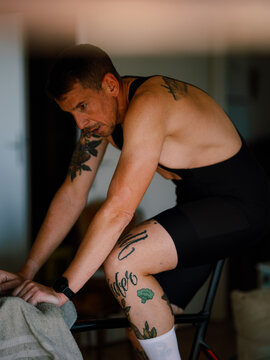 Tattooed Cyclist sprinting on his indoor bicycle