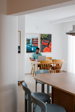 An online business owner working at a dining room table