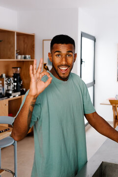 Portrait of a Black man looking at the camera, giving a thumbs-up