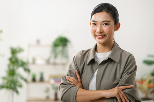 Young Asian woman with arms crossed smiling confidently