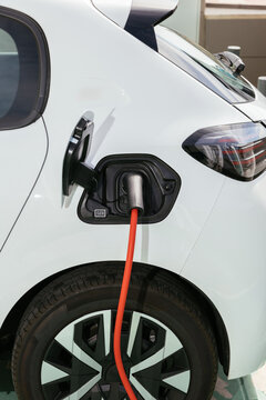 Electric car charging with orange cable for sustainability