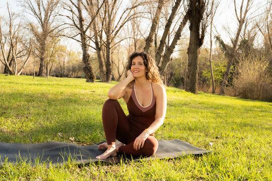 Enjoying yoga outdoors in spring under blue sky with green grass