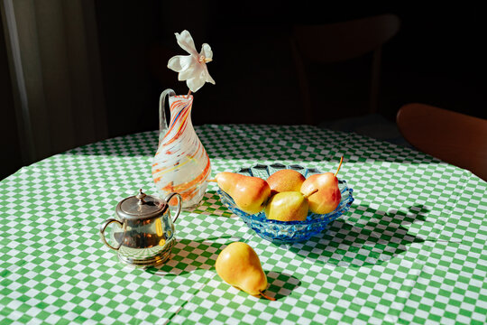 Fruit and tea set on a green checkered tablecloth