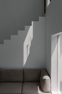 Armchair in a contemporary home, framed by sunlight and stairs