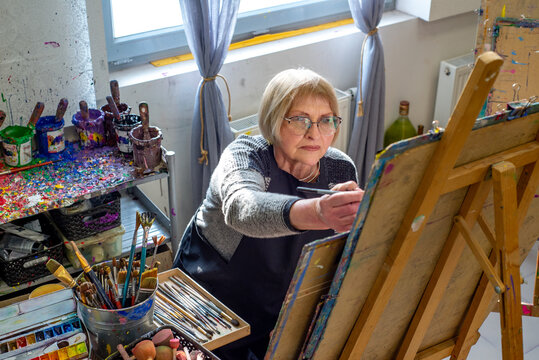 Elderly woman learning to draw in the workshop