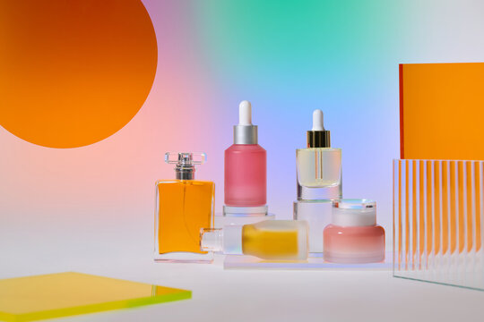 Assortment of elegant skincare bottles and jars arranged on glass
