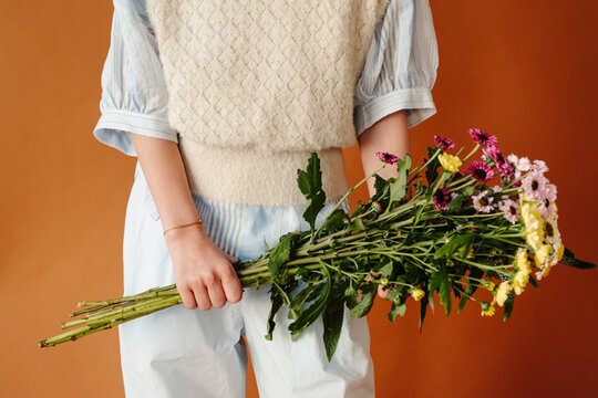 close up of young teen holding floral bouquet in studio