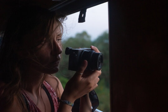 Woman holding camera by train window