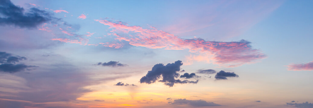 Beautiful vibrant sunset sky background with colorful soft pastel clouds for inspirational nature wallpaper panorama mockup