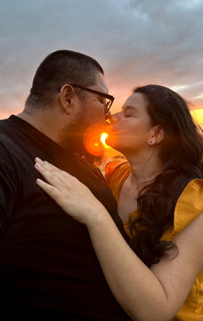 Couple kissing at sunset celebrating love and romance
