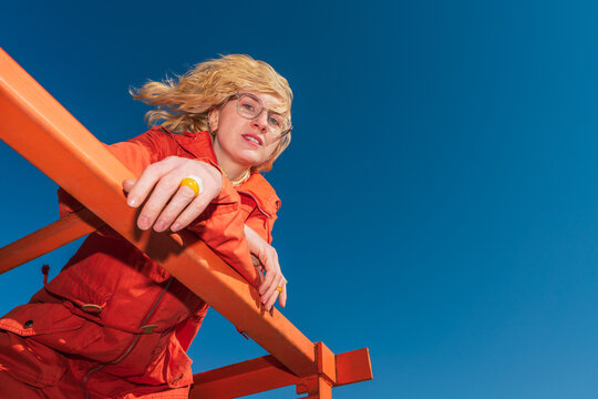 Low angle view of woman leaning on orange railing