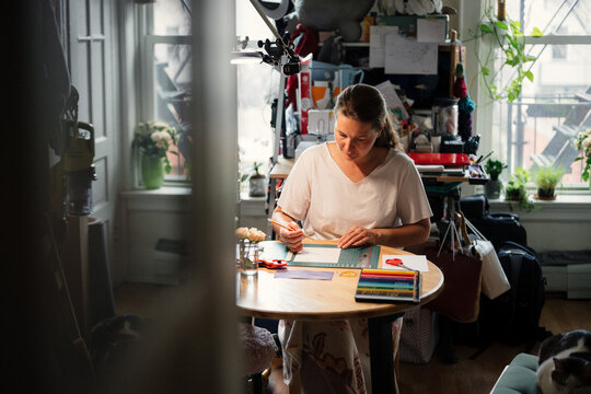 Woman Working on Art Project at Home Studio in Afternoon Light