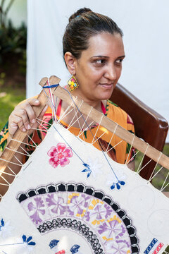 Traditional embroidery craftswoman holding textile on frame