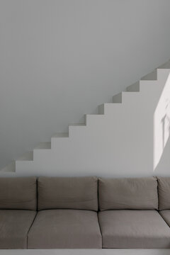 symmetrical view of a minimalist armchair framed by stairs