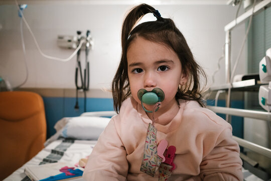Young girl patient with pacifier in hospital ward