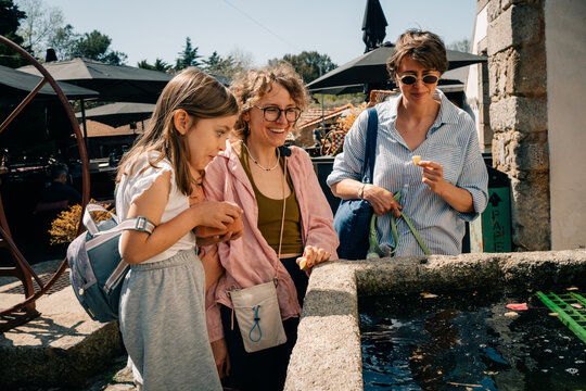 Friends Enjoy Time at a Garden With Water Feature and Plants