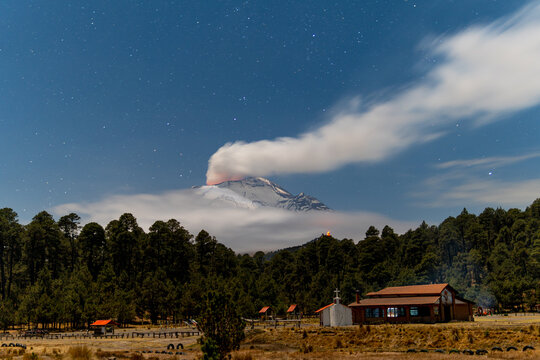 Popocatepetl volcano erupting at night under starry sky, mexico