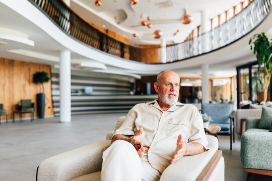 Business Senior Man Talking with Someone in Hotel Lounge