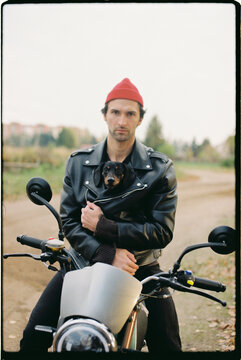 A man on a motorcycle with a dog.
