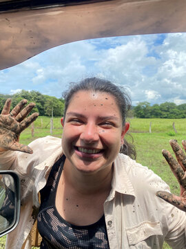 Happy woman enjoying muddy adventure in nature