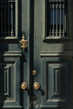 Close-up of vintage green door with brass handles