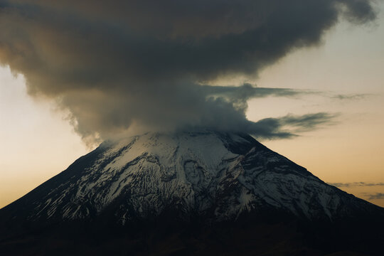 Popocatepetl volcano smoking with snow covered summit at sunset