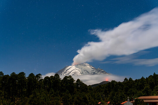 Popocatepetl volcano erupting under starry night sky