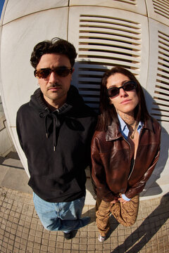 Young adults pose against a building in urban setting