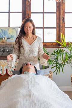 Woman Practices Energy Healing in a Bright Indoor Space