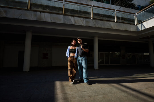 Couple stands together in a building with a bright outdoor light