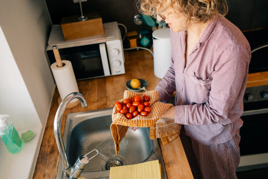 Person Washing Tomatoes in Kitchen During Daytime