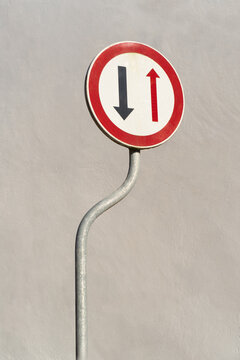 Minimal road sign with opposing arrows on neutral wall