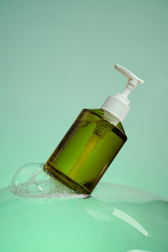 Green liquid soap dispenser bottle with white pump in bubbly water