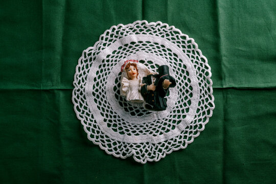 a fragmented bride and groom figurine framed by a doily