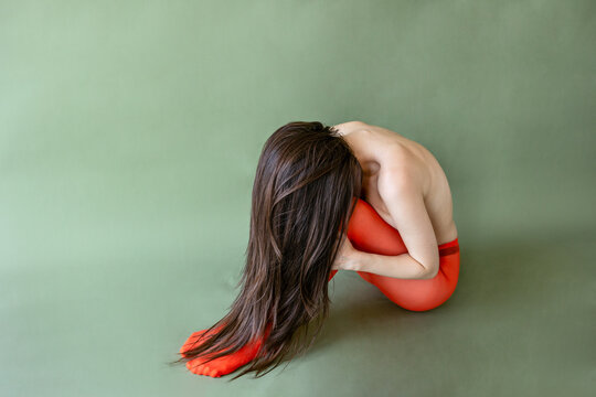 Model in orange tights on green backdrop